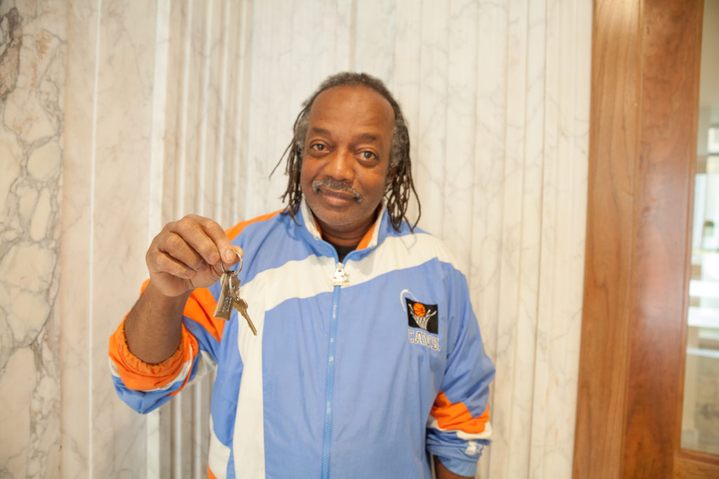 A man holding a house key in front of him.
