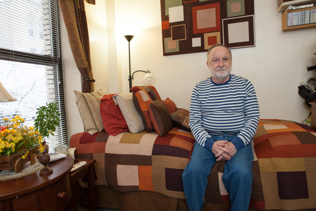 A man sitting on a bed.