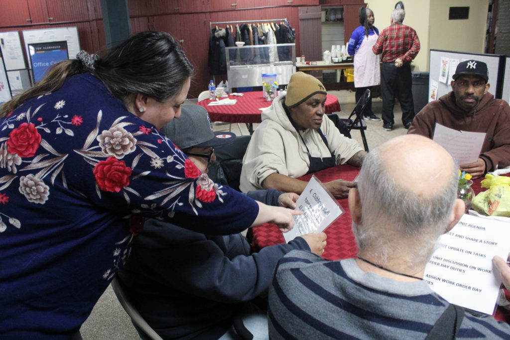 A TOP member distributes woksheets to other members during a TOP activiity.