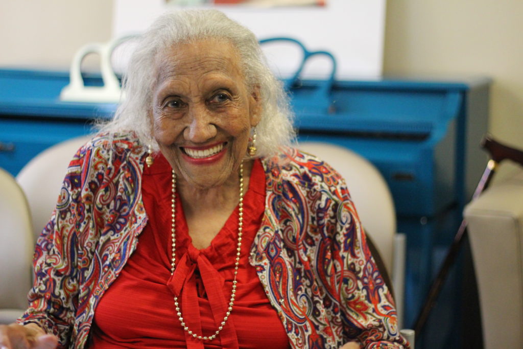 A woman sitting in a senior center community room.