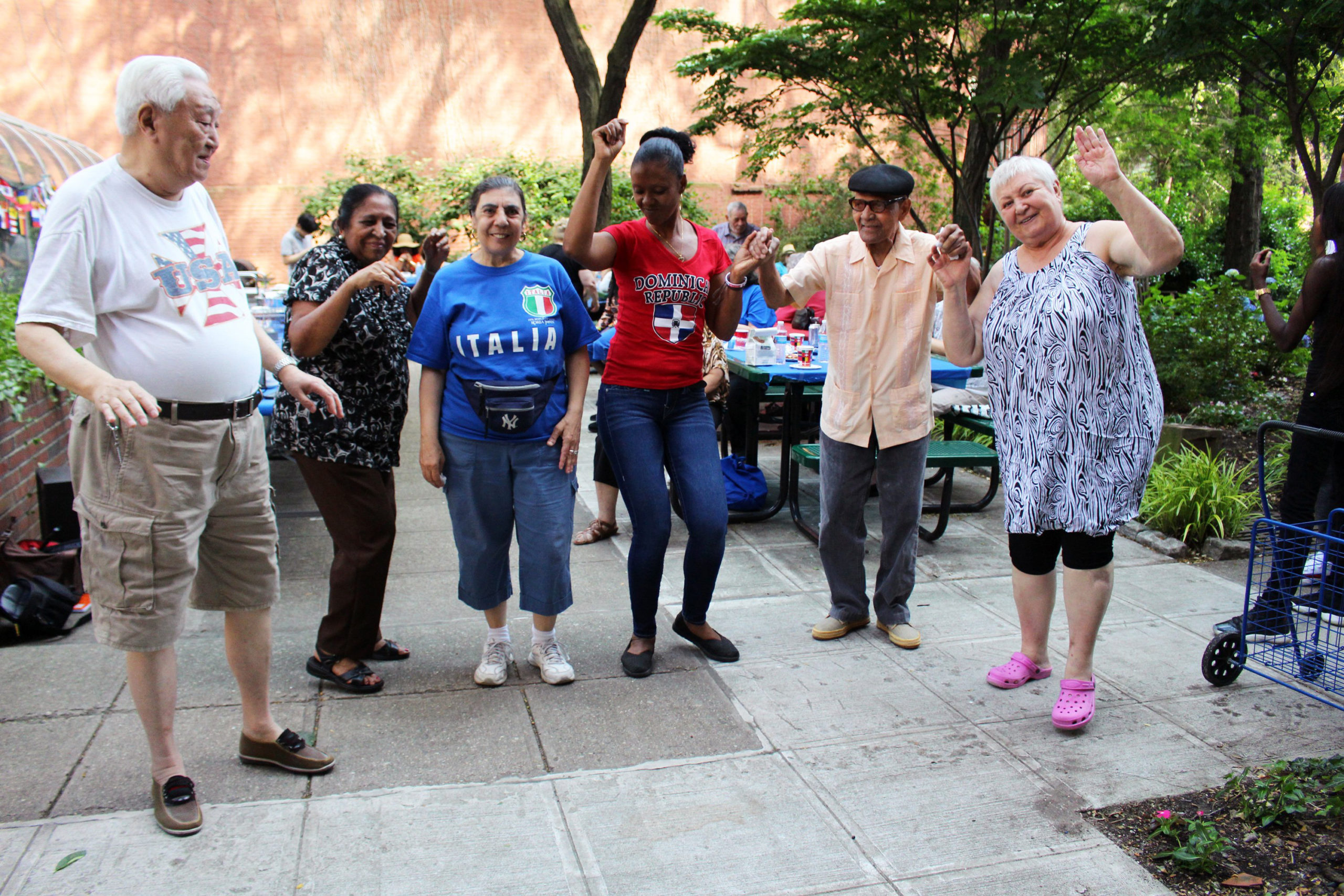 A group of older adults standing together at the Phelps House garden