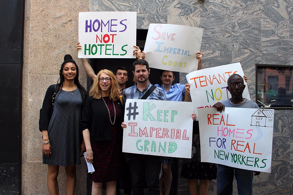 Activists hold signs reading Homes not Hotels