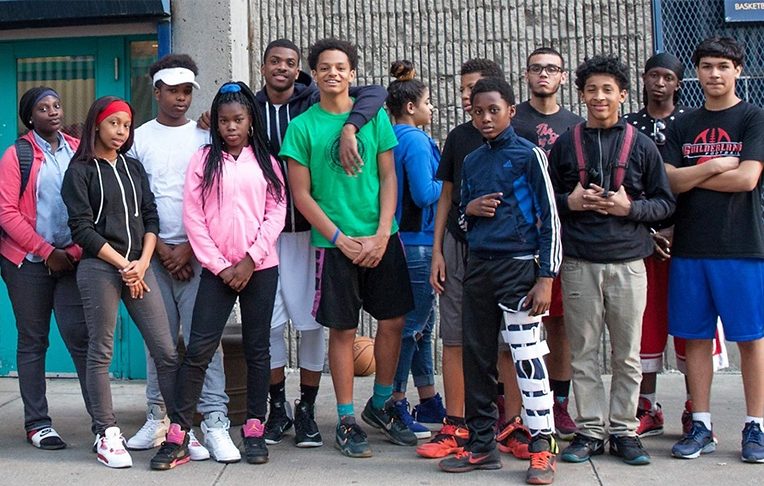 Young people stand in front of the Lincoln Square Neighborhood Center