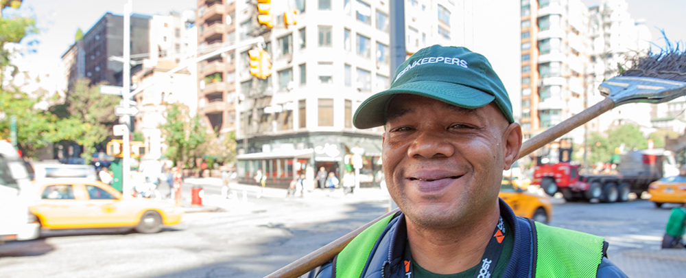 A man smiling with his Green Keepers uniform.
