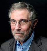 Headshot of Paul Krugman in a gray jacket and light blue dress shirt against a dark background