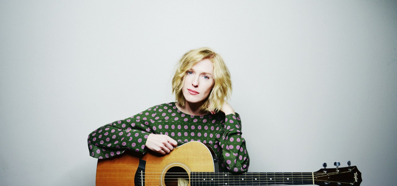 A woman holding a guitar