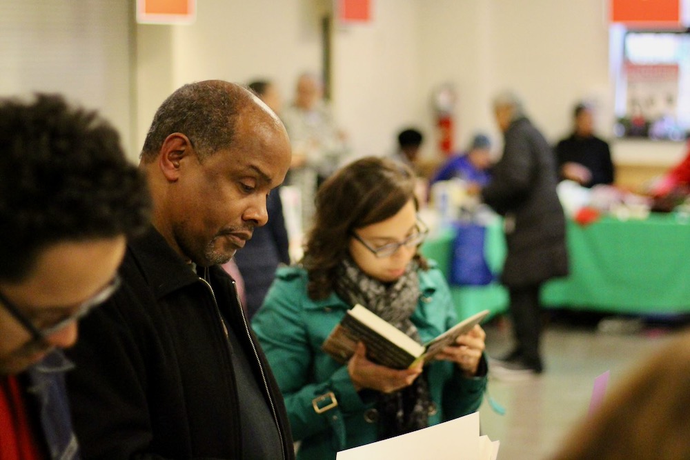 People browse through books at long tables 