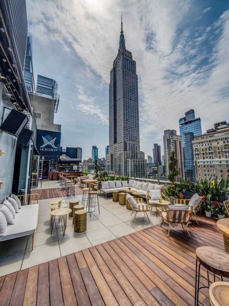 A wooden deck with lounge chairs and a view of the Empire State Building