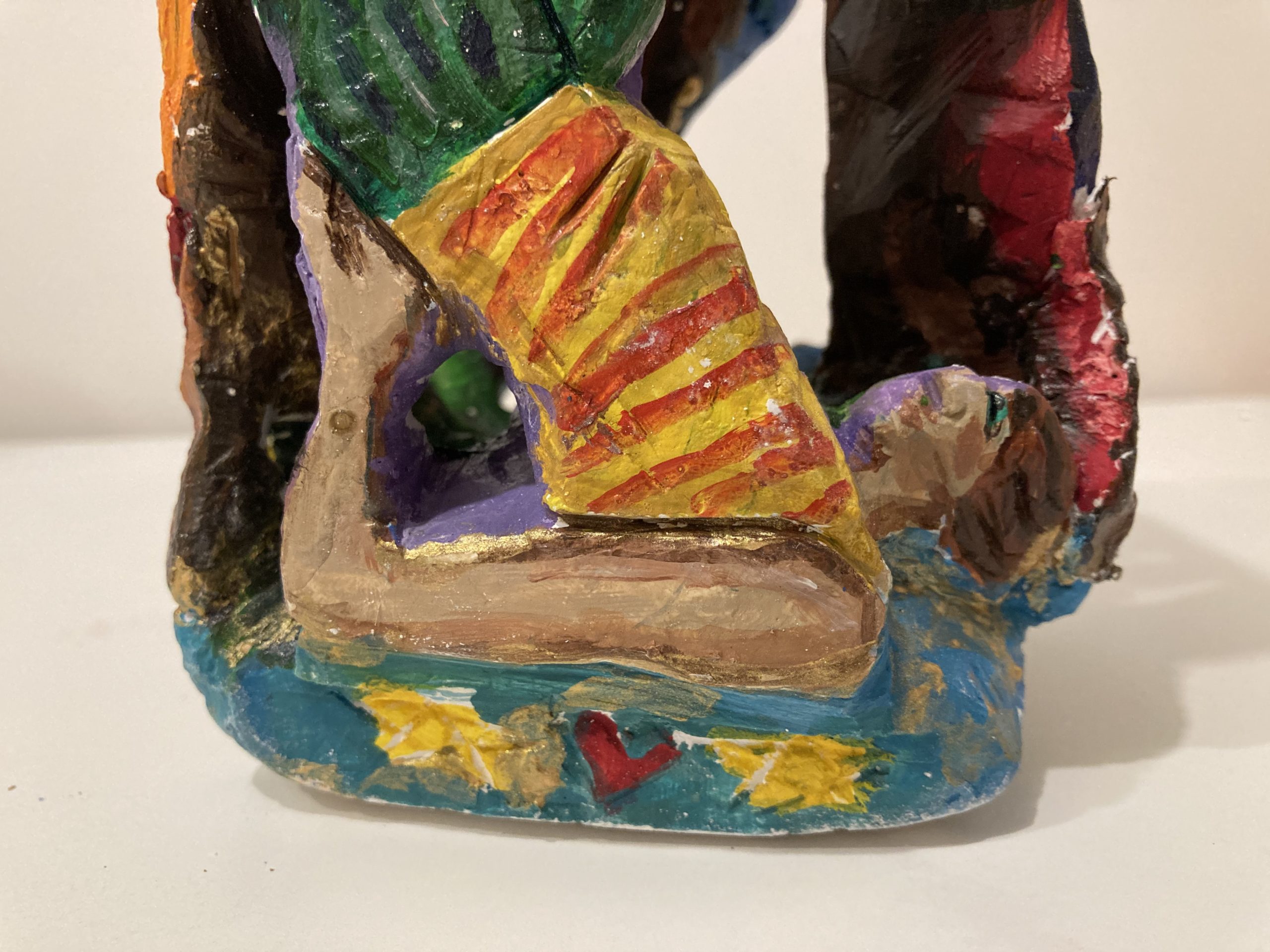 A sculpture of a woman on her back, stretching her legs upwards titled All Together now