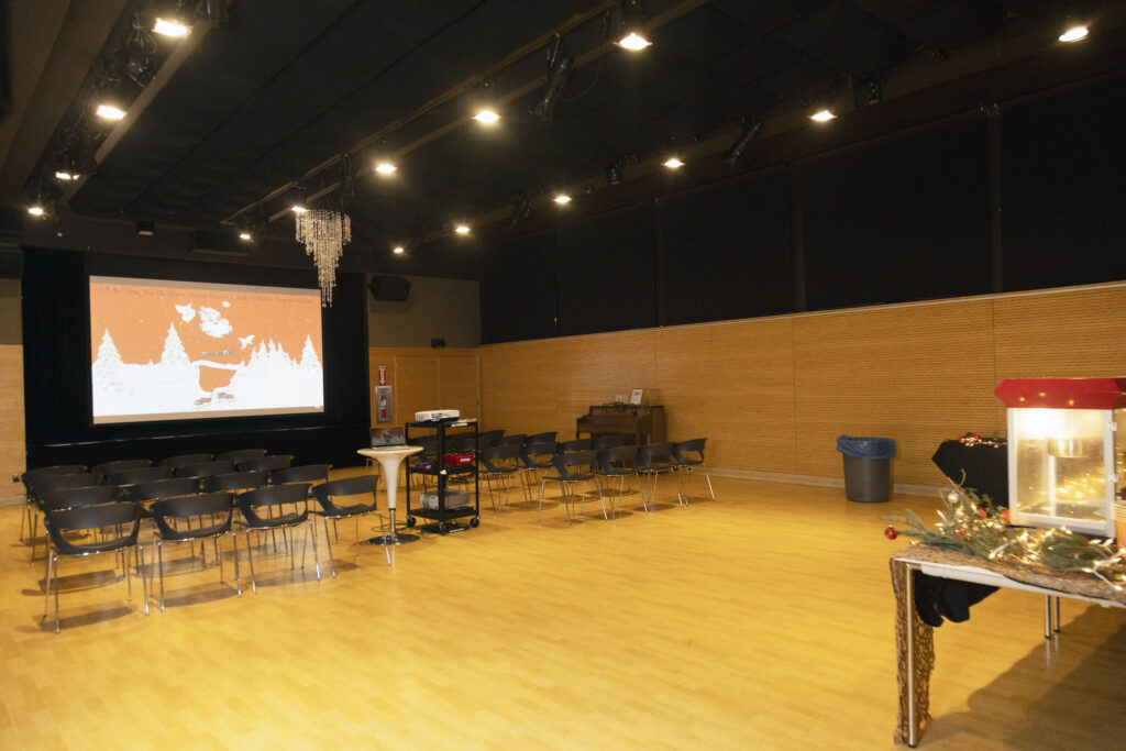 Auditorium with open floor space. Set up with chairs and a projector.