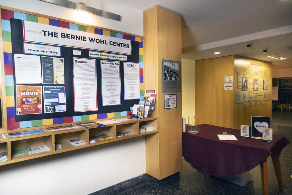 Lobby of the Bernie Wohl Center. Has a board with information and cubbies for handouts. A table is set up with a tablecloth as a box office.