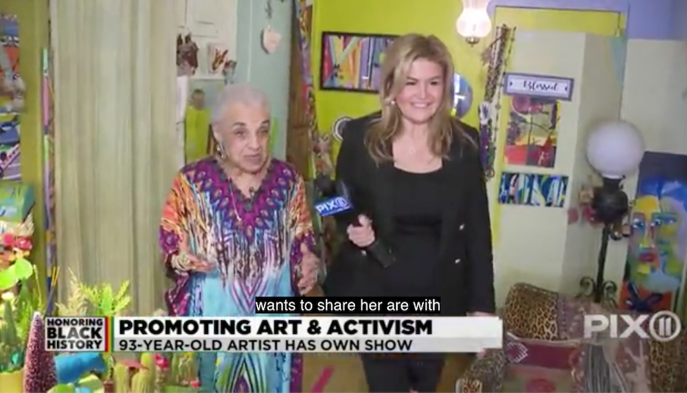 Two women walk through a colorful art-crammed apartment in a screengrab from PIX 11
