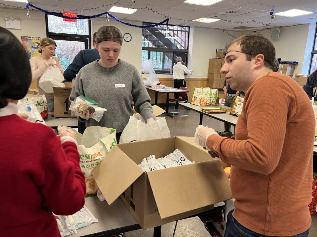 Volunteers at Goddard Riverside dining hall pack holiday food into donation bags. 