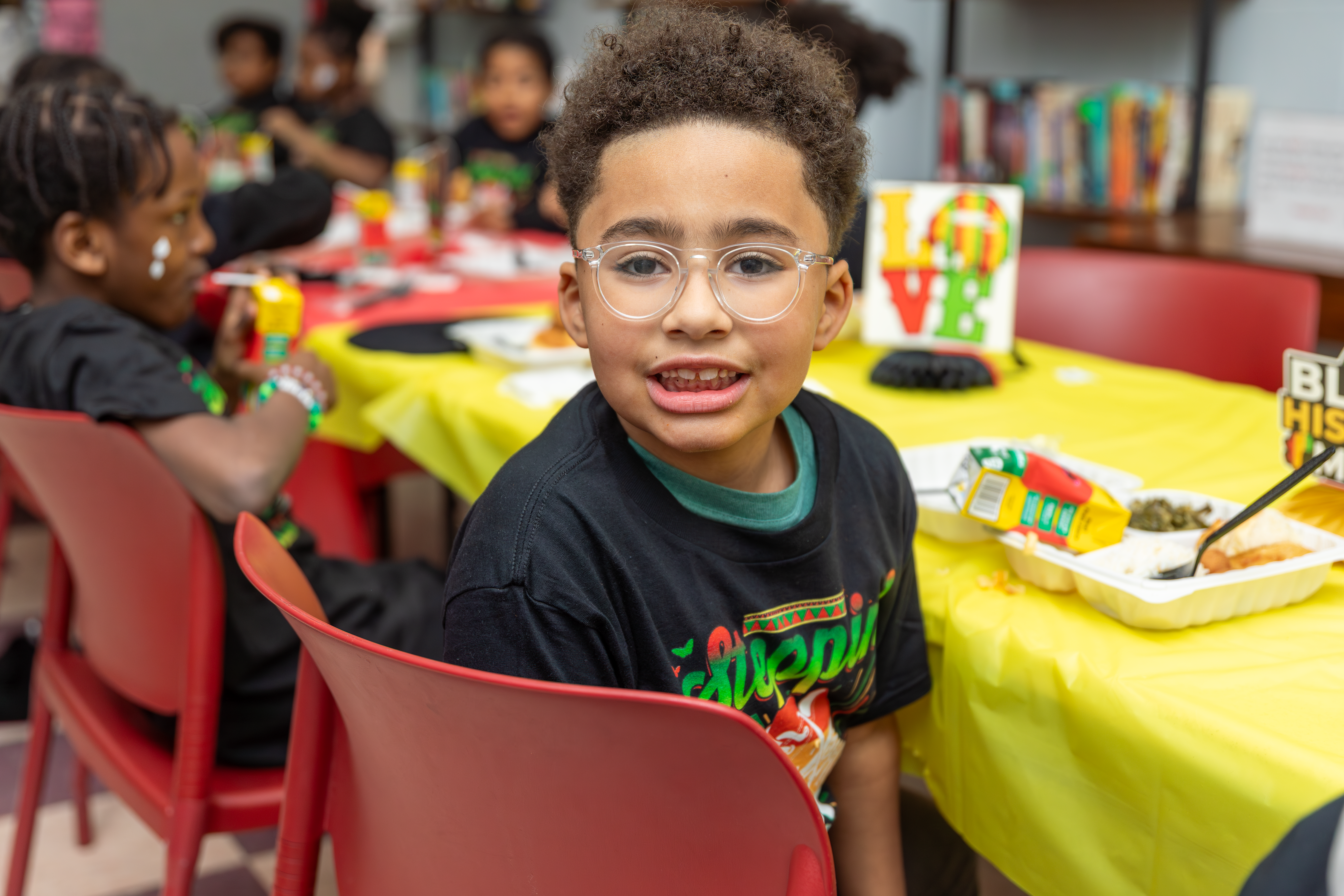 Boy sitting at a table smiling 